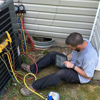 HVAC technician checking a Trane outdoor air conditioning unit during AC service