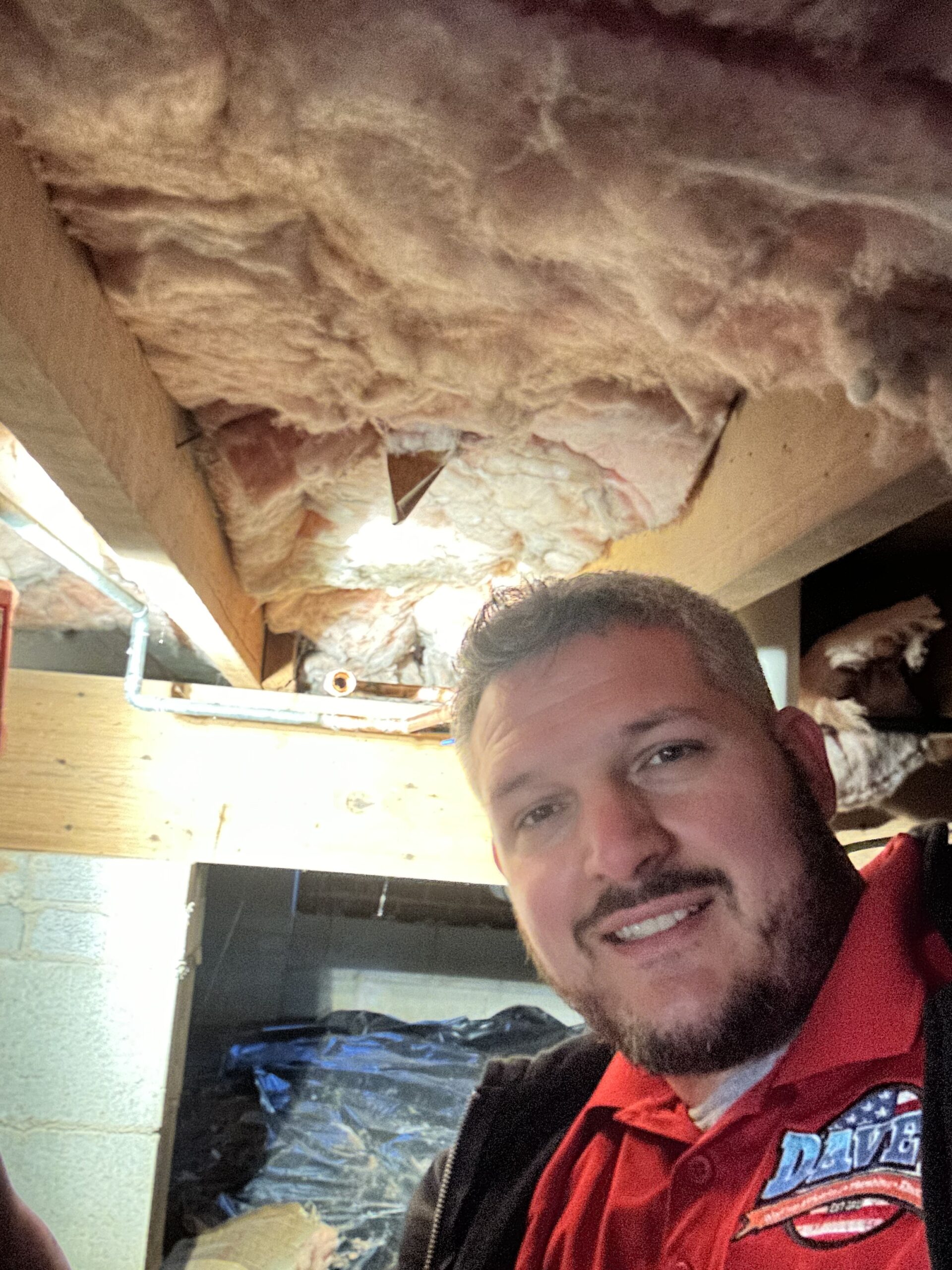 Dave's plumbing technician working in a crawlspace in Upstate South Carolina