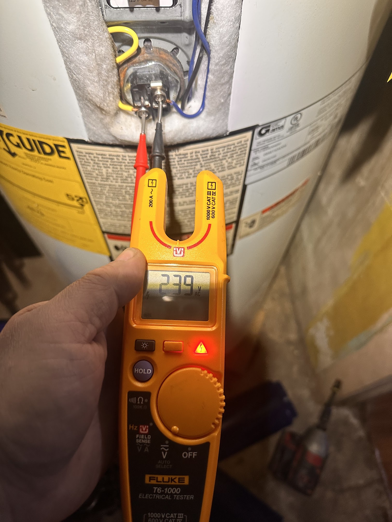 Testing electric water heater elements and thermostat with a meter during plumbing diagnostics