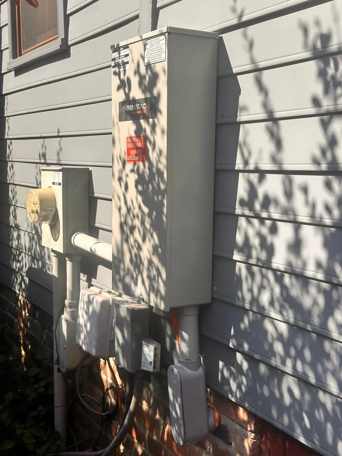 Generac automatic transfer equipment mounted near a home electrical service